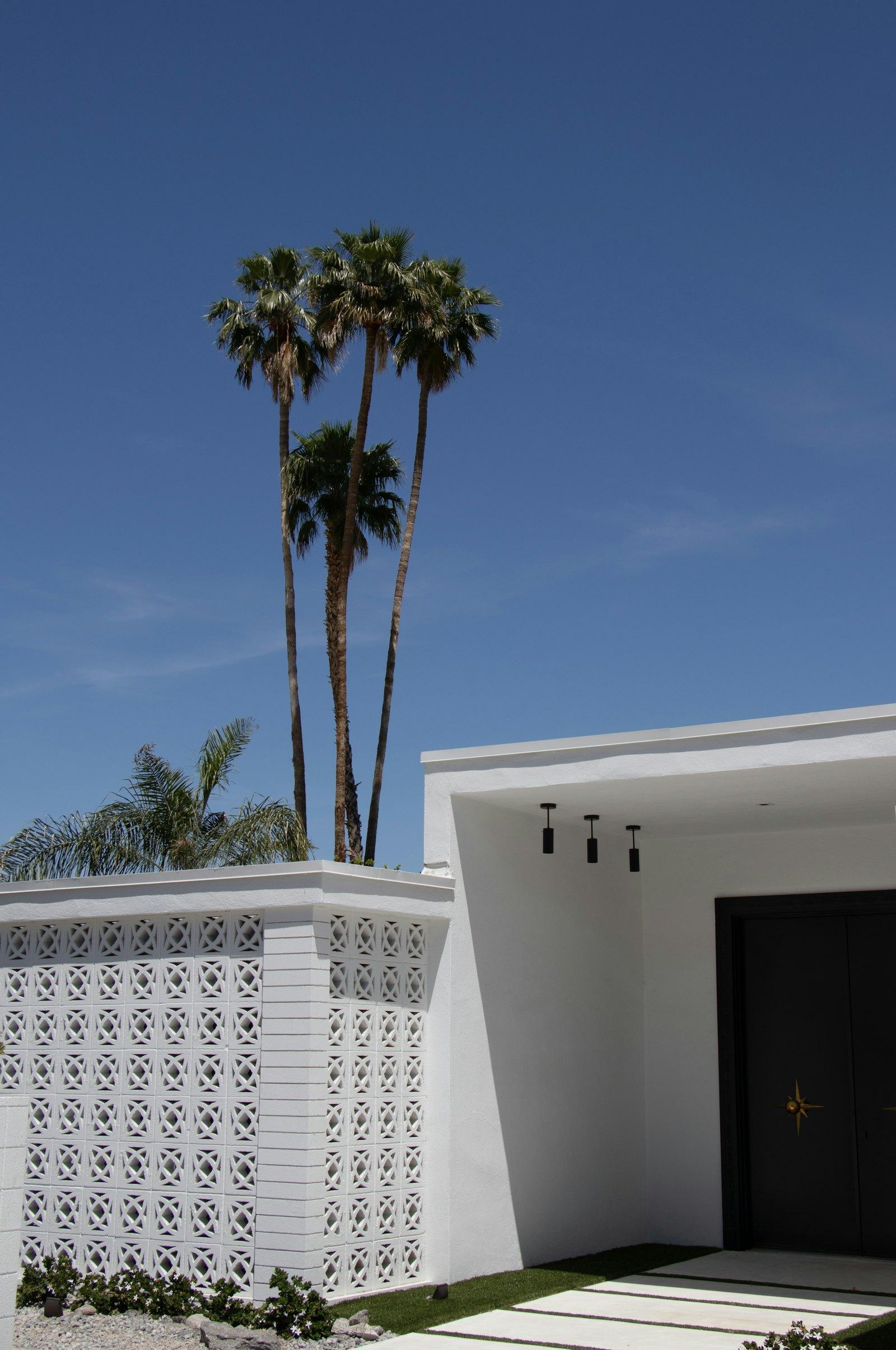 White roofline and patterned screen wall under a blue sky